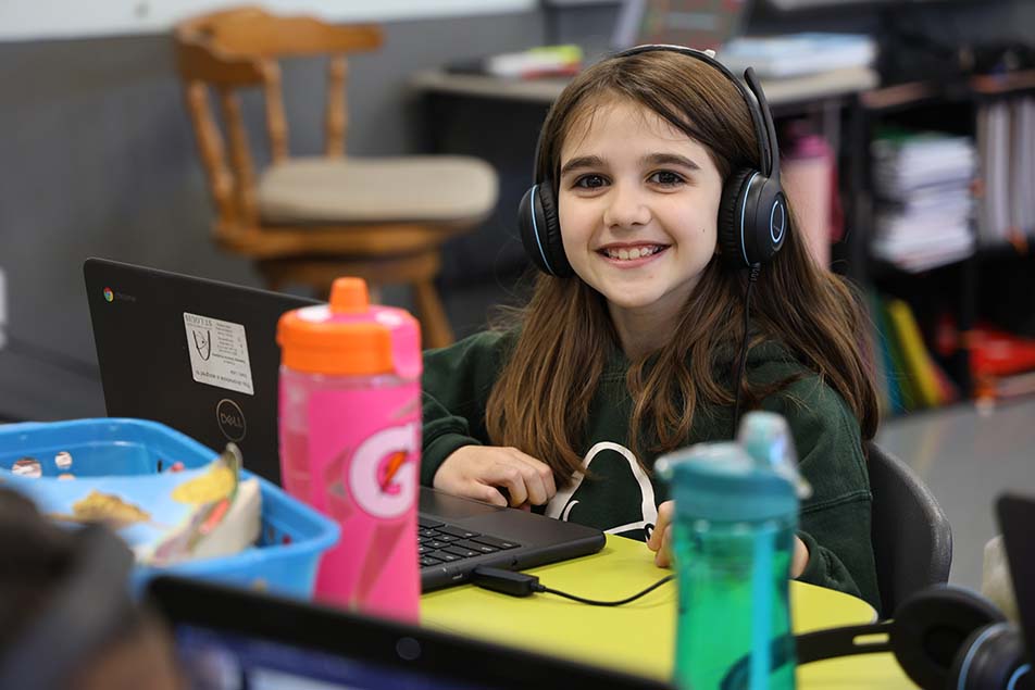 student in classroom smiling at camera