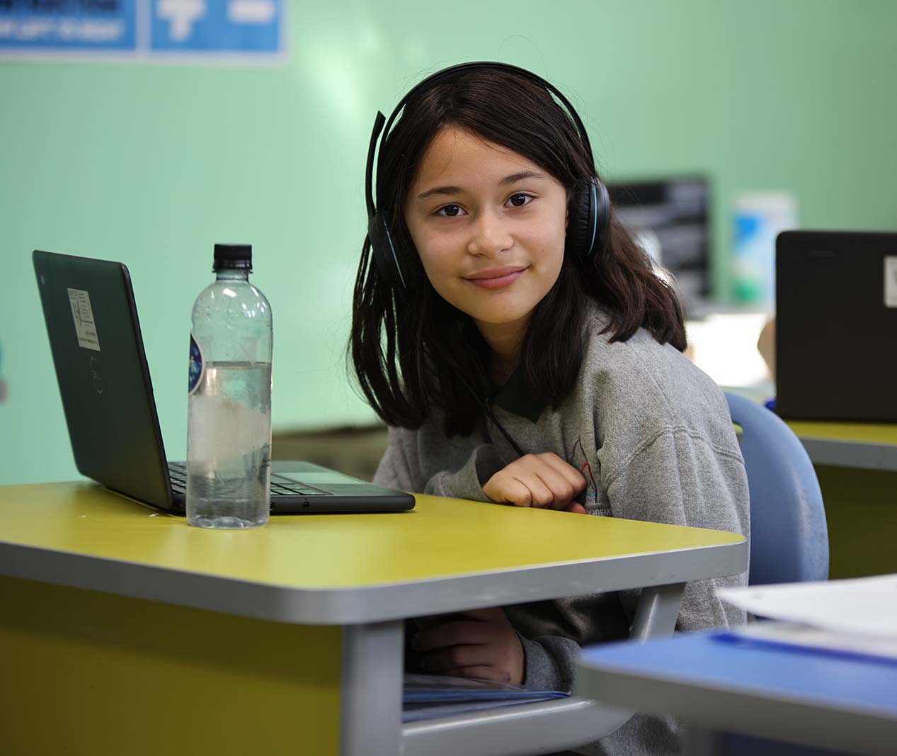Student working on a notebook in a classroom.